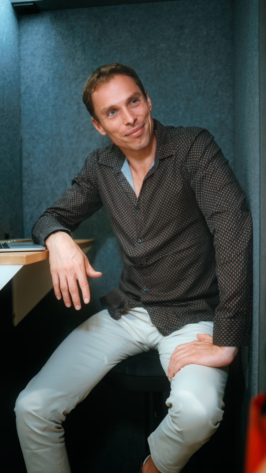 Sébastien Roger sitting relaxed and smiling, in a patterned shirt